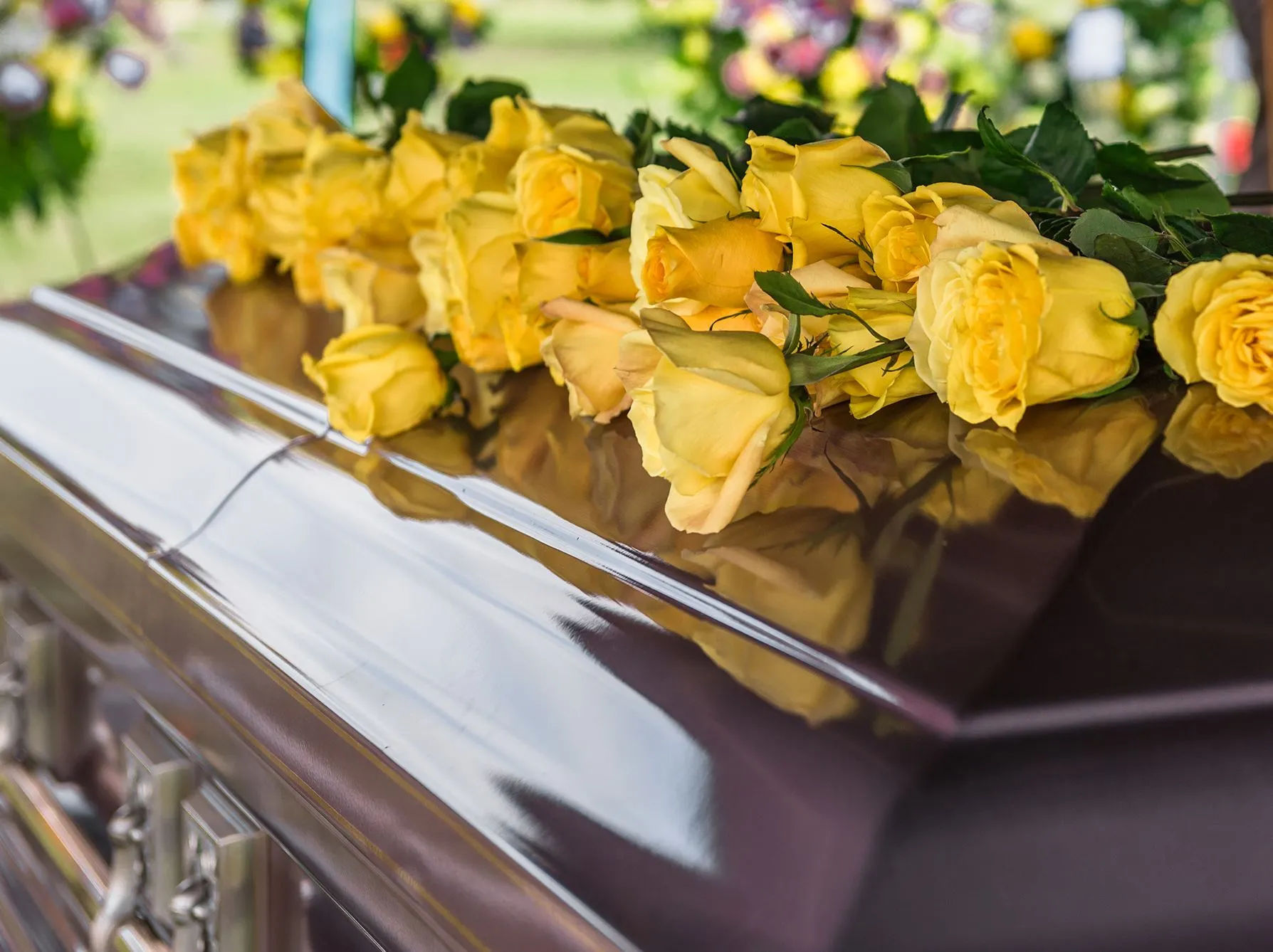 yellow rose on top of a casket